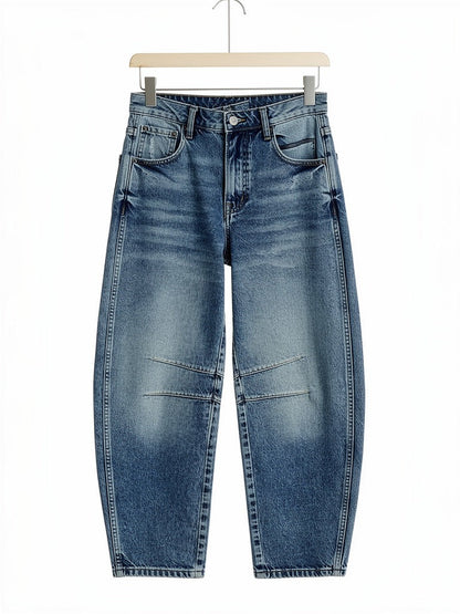 Vintage Blue barrel jeans on a wooden hanger, showing the curved leg and the two knee seams