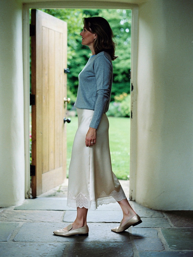 Satin midi skirt with a scalloped lace hem in Vanilla, worn in profile