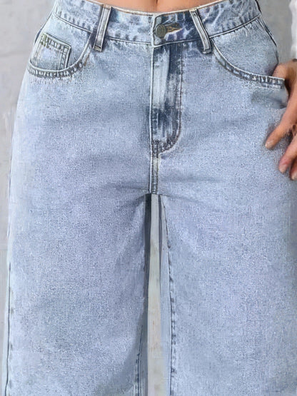 Close detail of the high waistband, button, fly and coin pocket of the wide-leg jeans