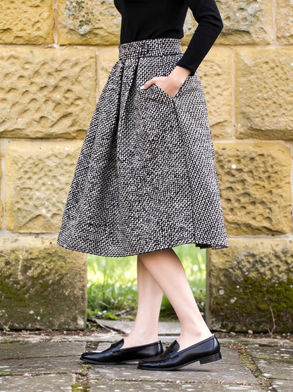 Back view of the black and white herringbone A line skirt, showing how the thick pleated cloth stands away from the body