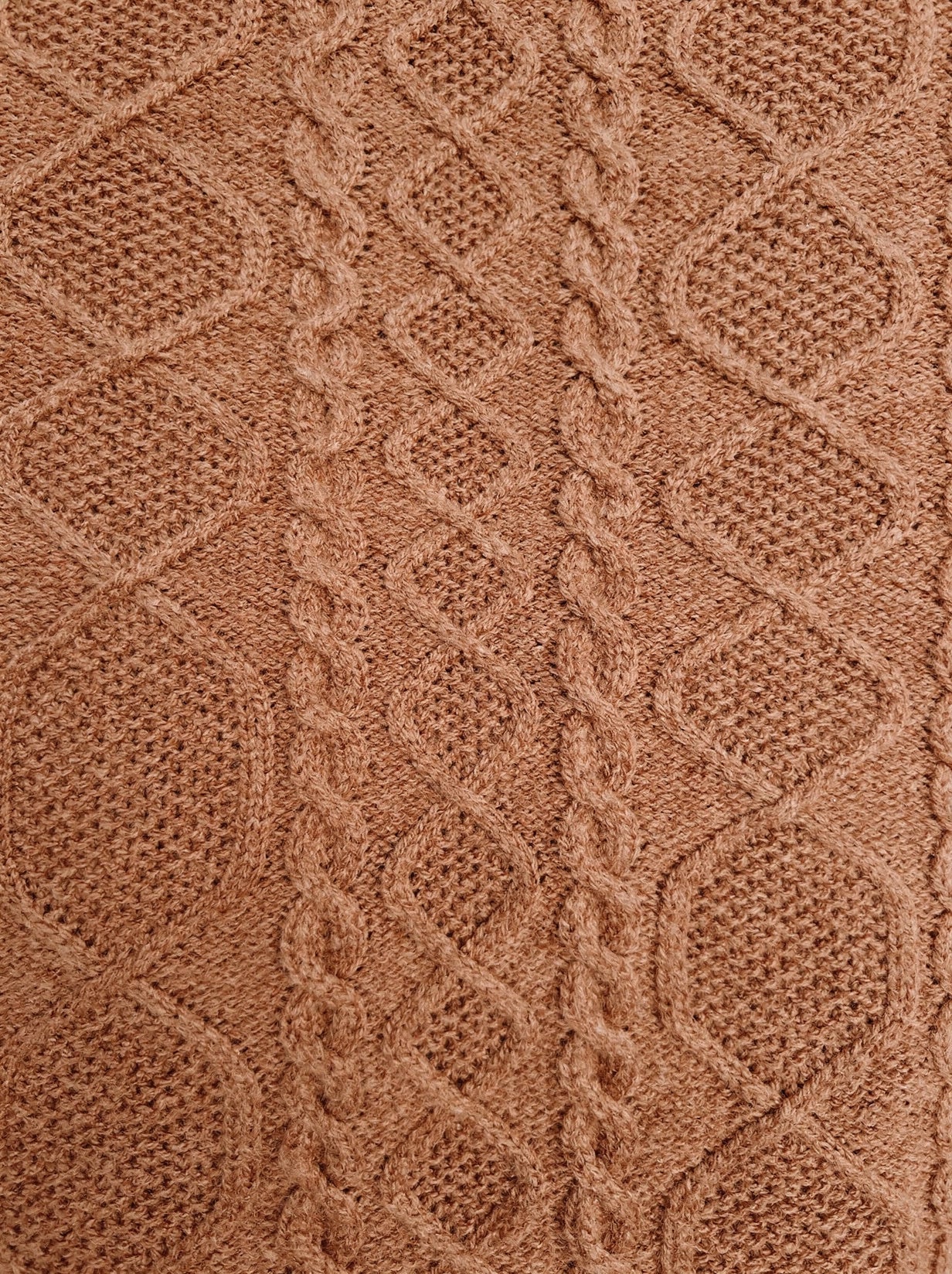 Close-up of the Aran diamond and rope cable texture of the camel knitted dress
