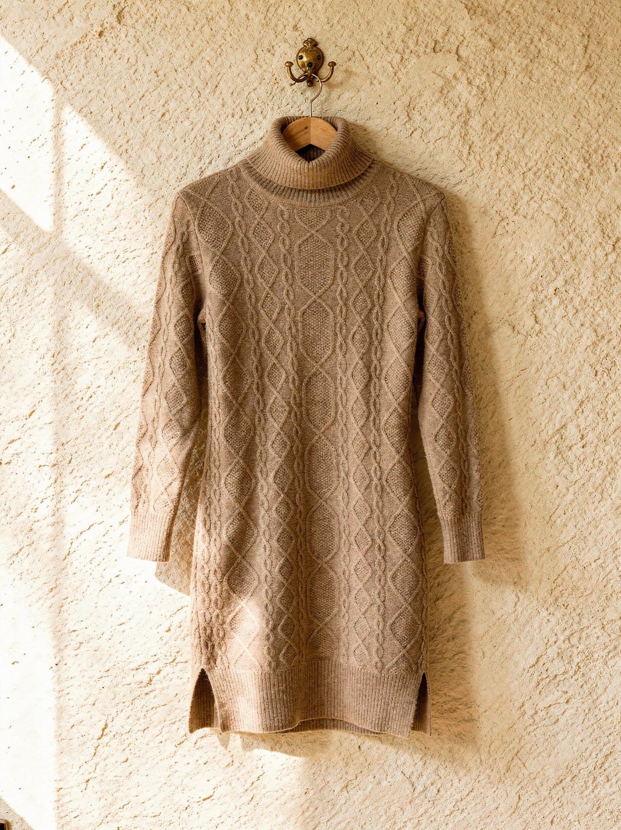 Camel Aran cable-knit polo-neck jumper dress on a wooden hanger