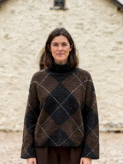 Argyle jumper seen close up, short mock neck and boxy body in chocolate brown and black