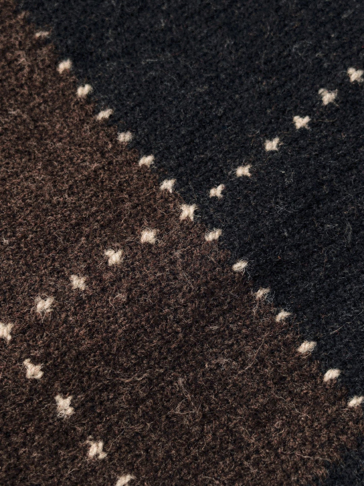 Close up of the brushed argyle knit, chocolate brown and black diamonds with fine cream dotted lines