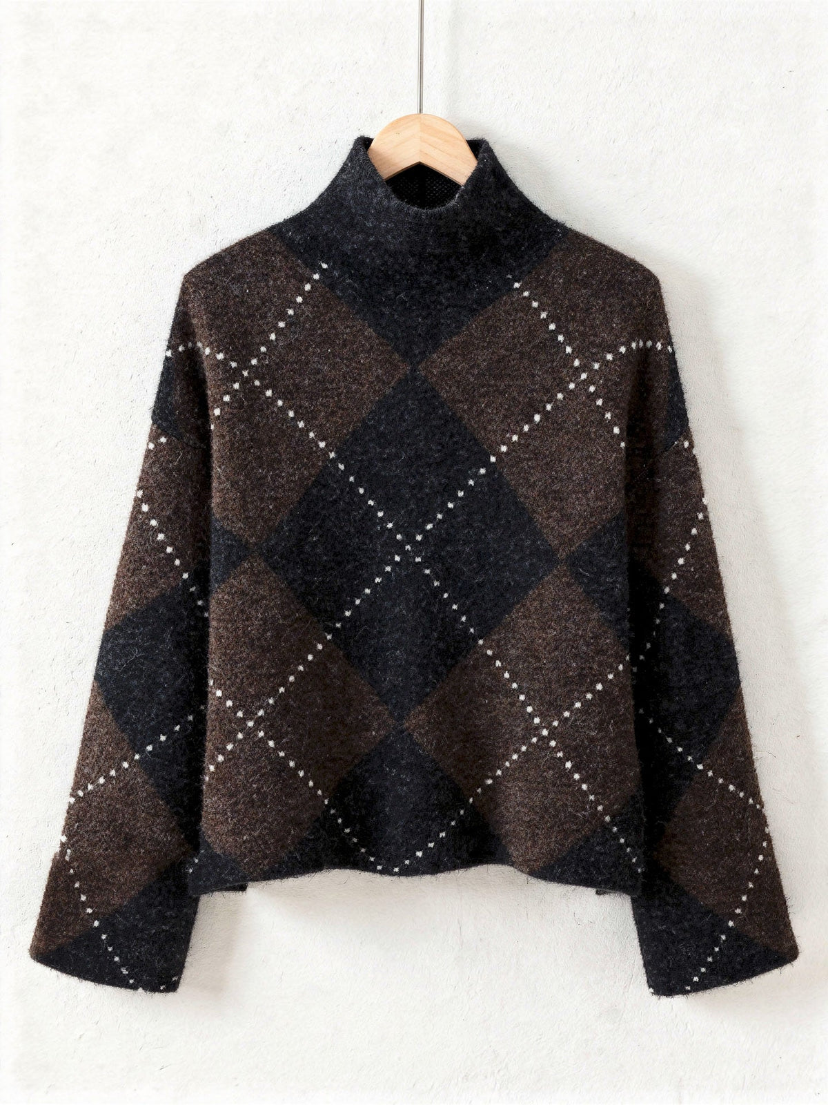 Argyle jumper in chocolate brown and black on a wooden hanger, front view