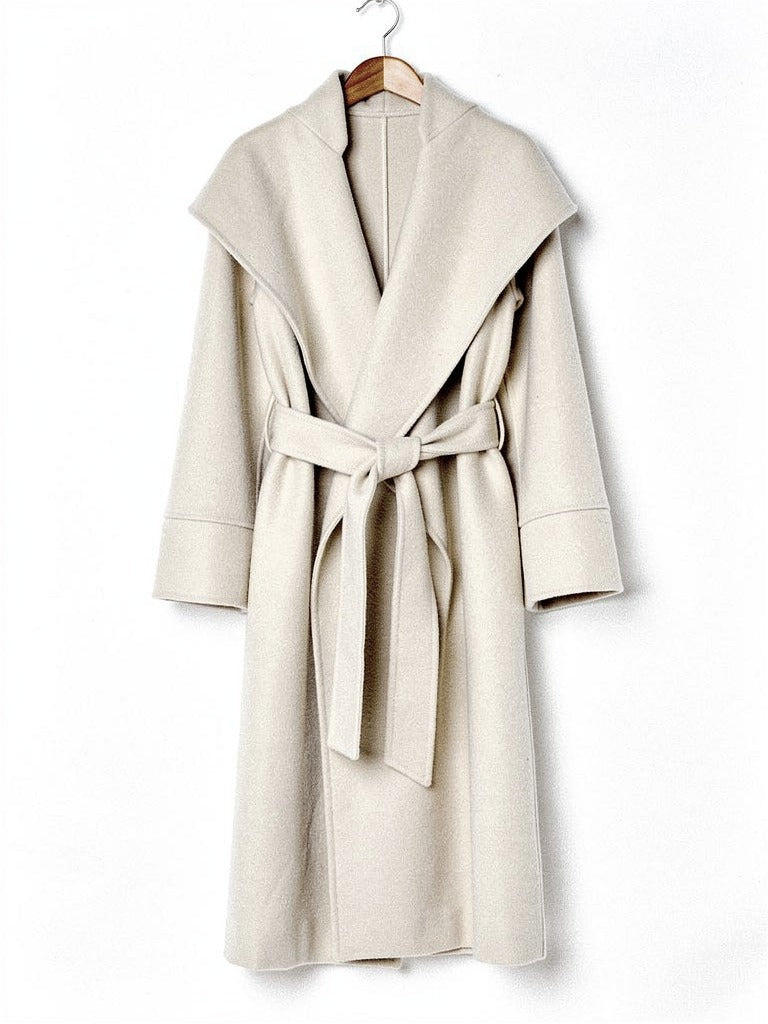 Belted wrap coat in Bisque cream on a wooden hanger, showing the deep shawl collar and the tied belt