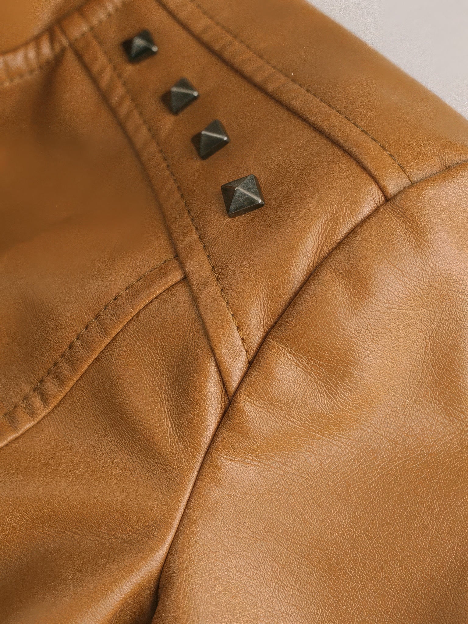Pyramid stud and grain detail on camel faux leather biker jacket