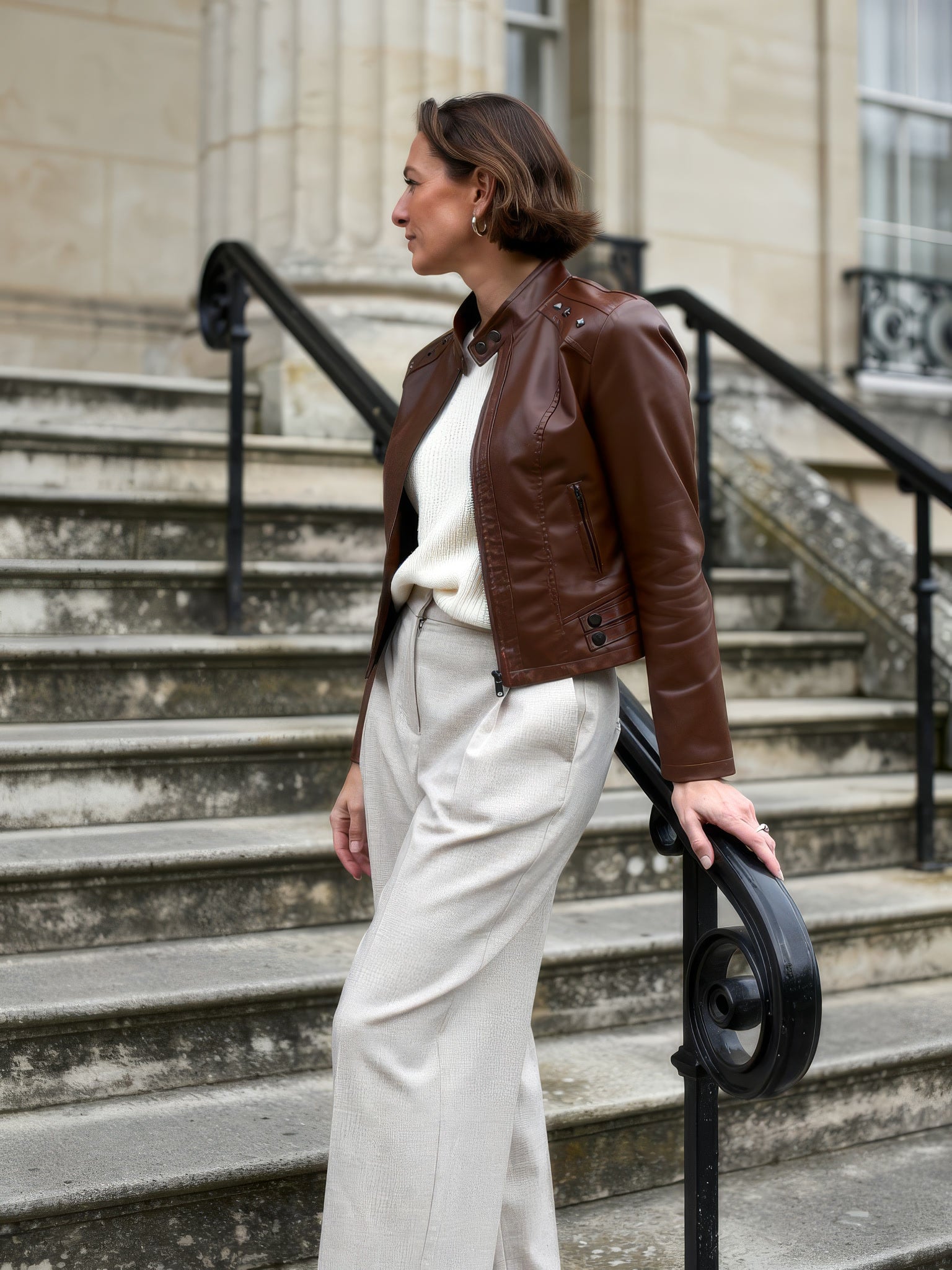 Chestnut brown faux leather biker jacket on stone steps