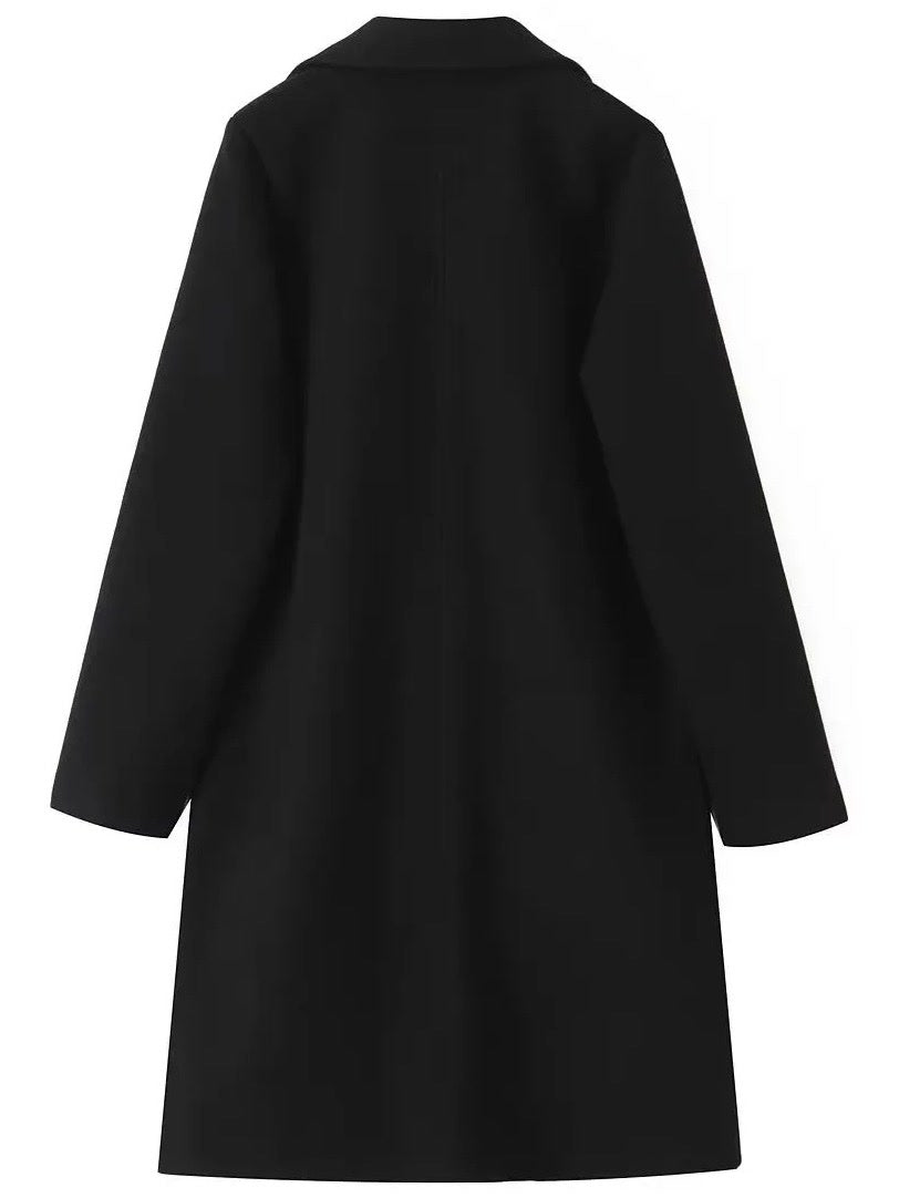 Black coat laid flat from the back, showing the plain panel and the straight hem