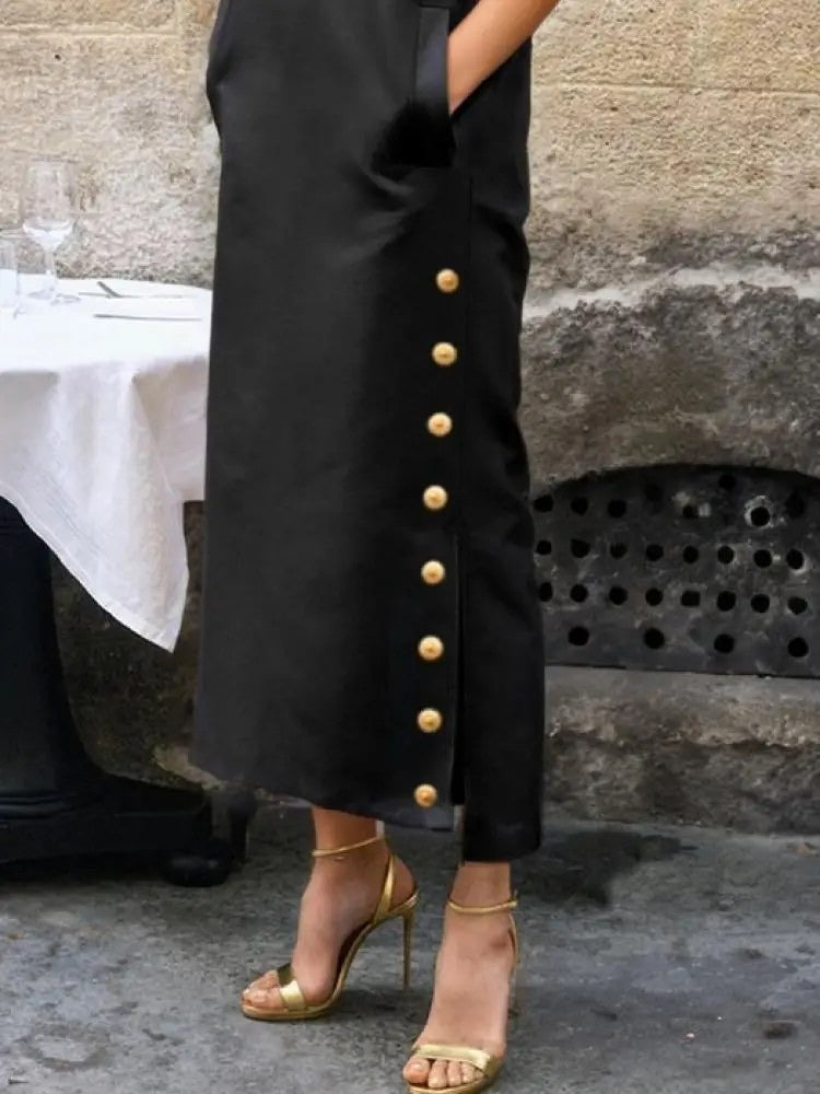 Gilt ball buttons and the side split on the skirt of the black column dress