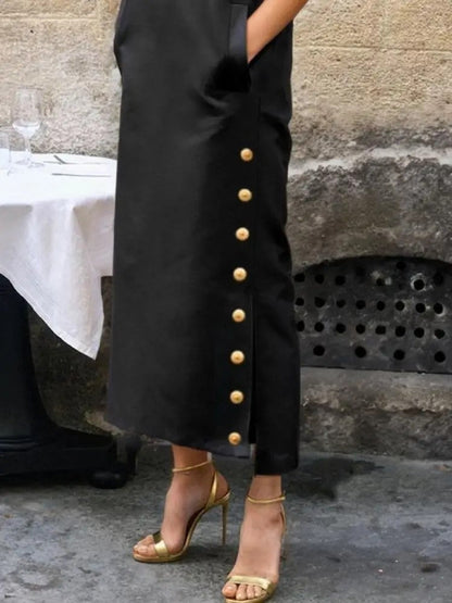 Gilt ball buttons and the side split on the skirt of the black column dress