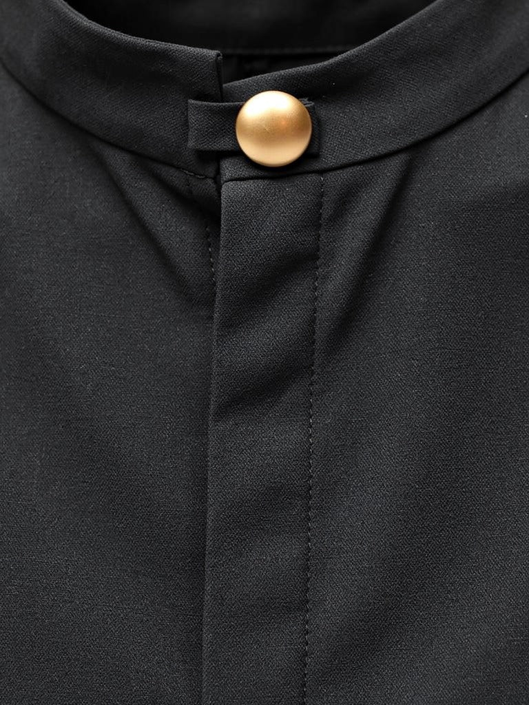 Close up of the stand collar and the single gilt ball button on the black column dress