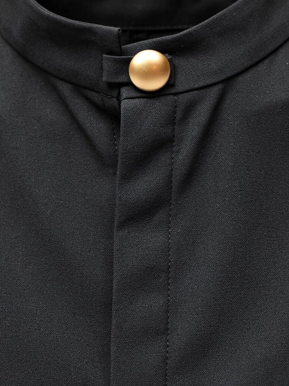 Close up of the stand collar and the single gilt ball button on the black column dress