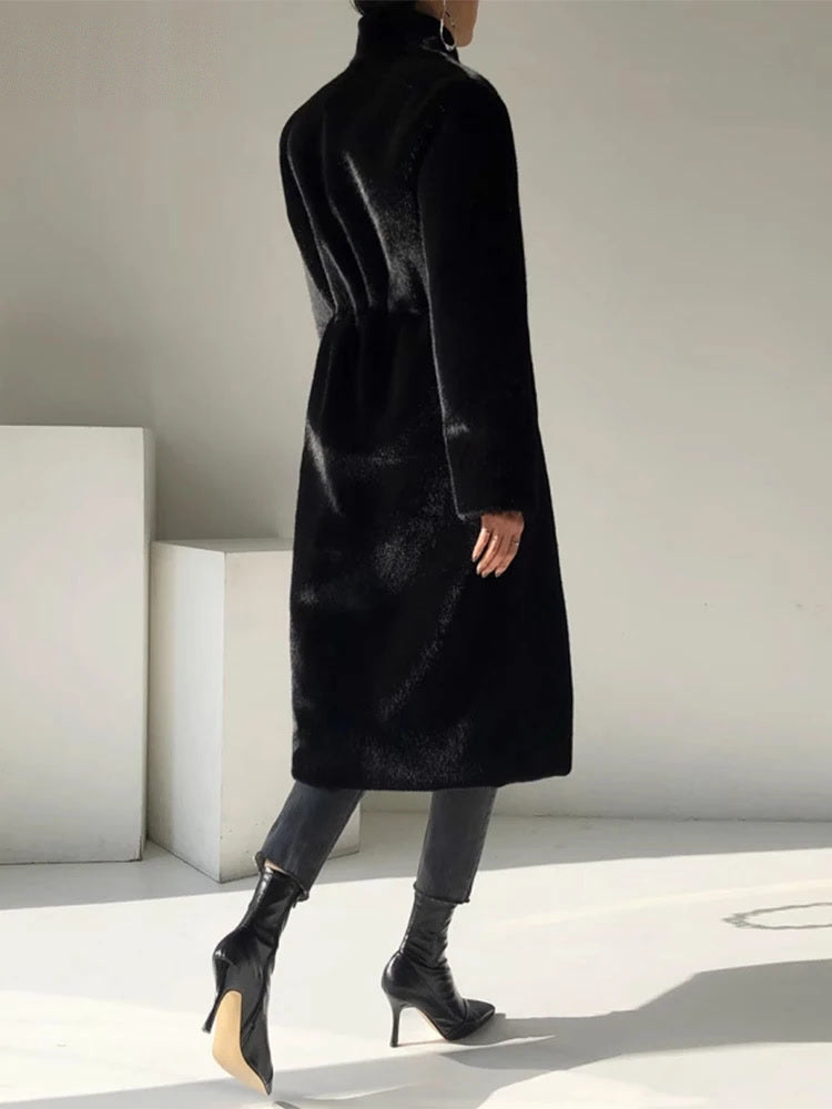 Black fluffy coat seen from the back, showing the stand collar and the gathered back waist