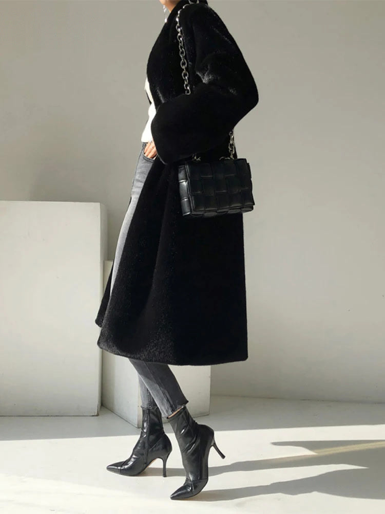 Black fluffy coat worn and seen from the side, showing the swing of the full length hem