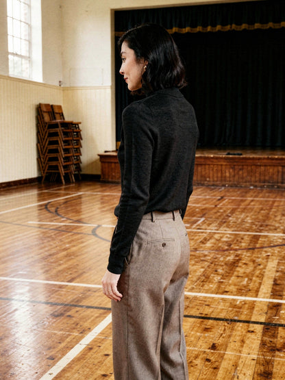 Back view of the black roll neck jumper worn in a village hall