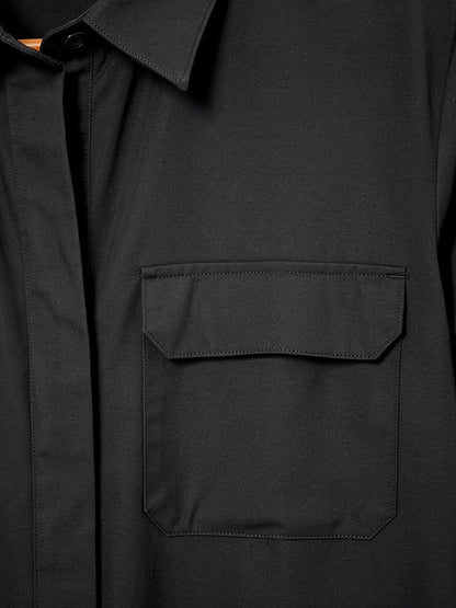 Close-up of the matte woven cloth, collar and flap chest pocket of the black shirt dress