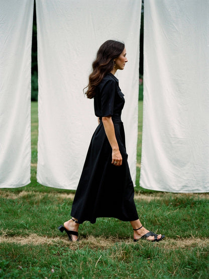 Black shirt dress worn walking, side profile, full length
