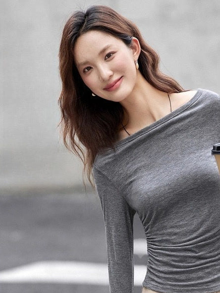 Smoke grey boat neck top worn off the shoulder, close view of the stretch jersey