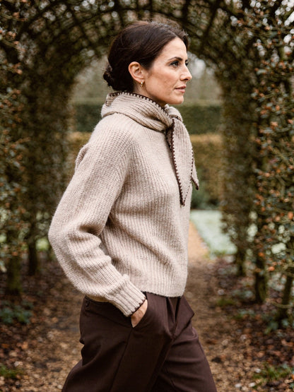 Side view of the bow neck jumper in Cashew, showing the stand collar and the short ribbed hem