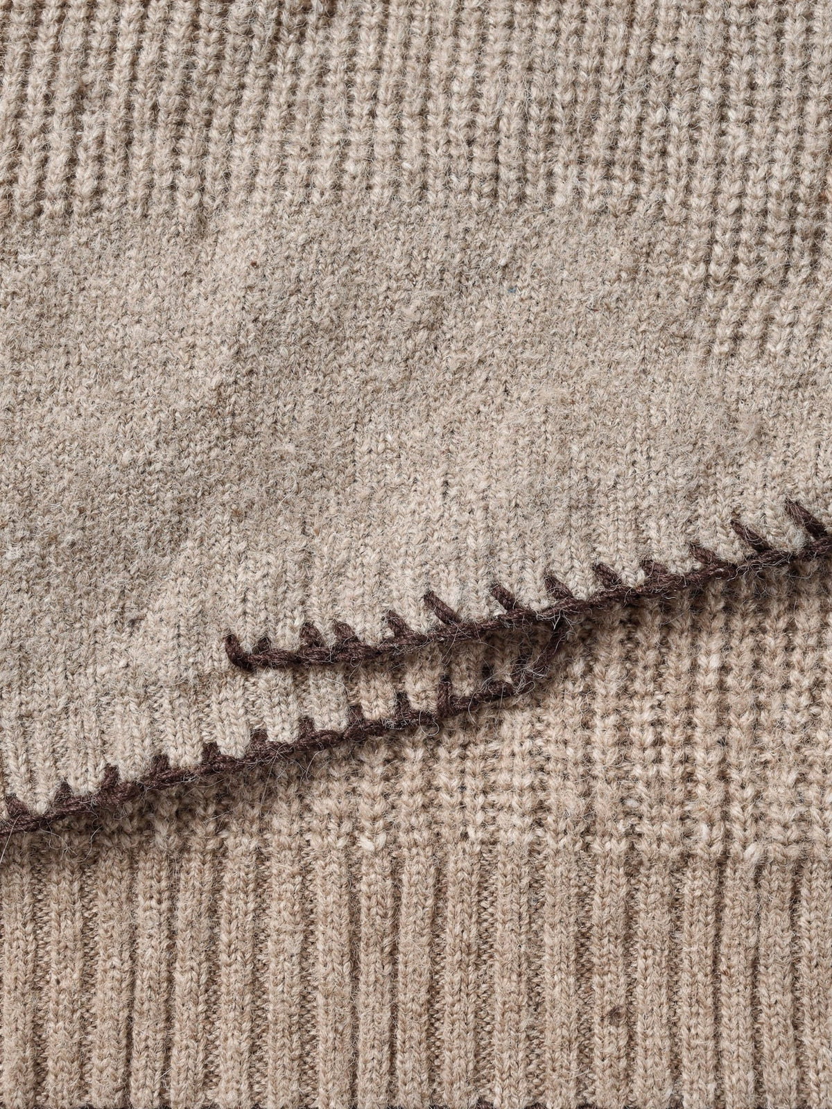 Close-up of the ribbed knit and the chocolate contrast whipstitch on the cuff of the bow neck jumper