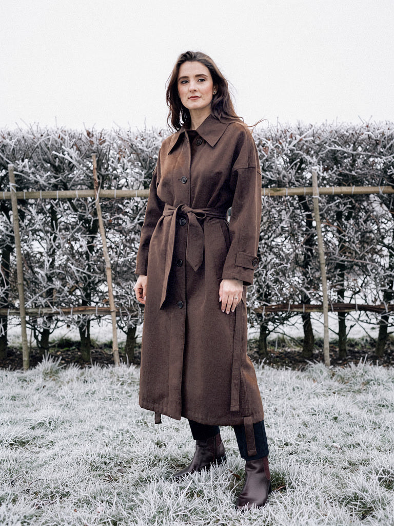 Brown coat in Carob, belted and worn long on a frosted winter morning