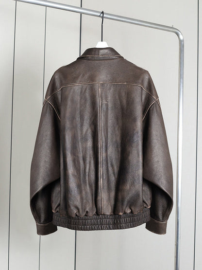 Brown distressed faux leather bomber jacket seen from the back on a hanger, in Bison