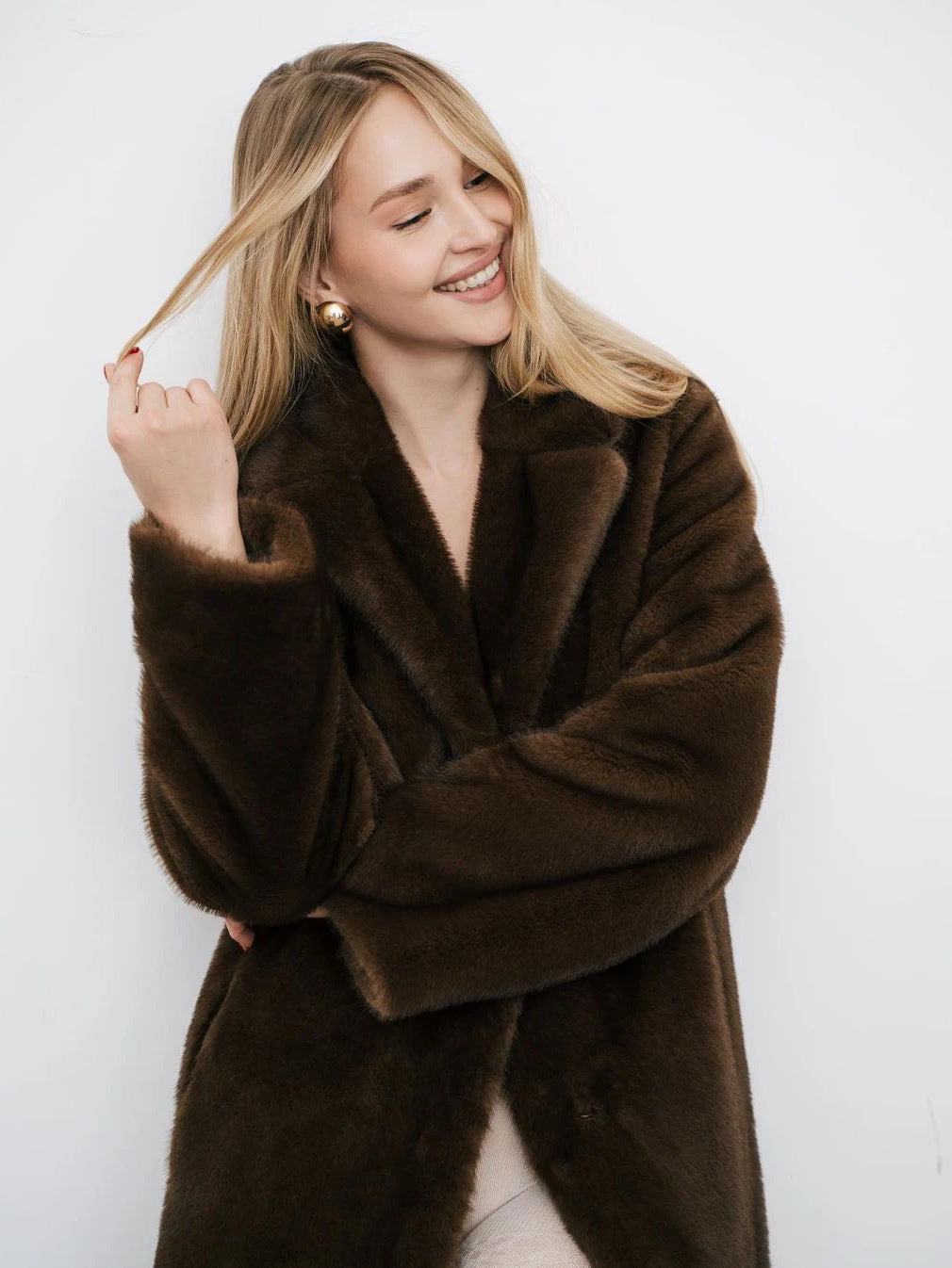 Brown faux fur coat worn open, showing the wide notch lapel and the dropped shoulder