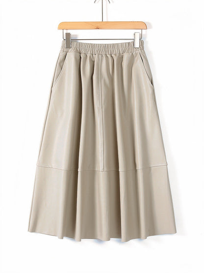 Faux leather skirt in Buff, a quiet pale sand, shown front on with the same gathered waistband and full A line