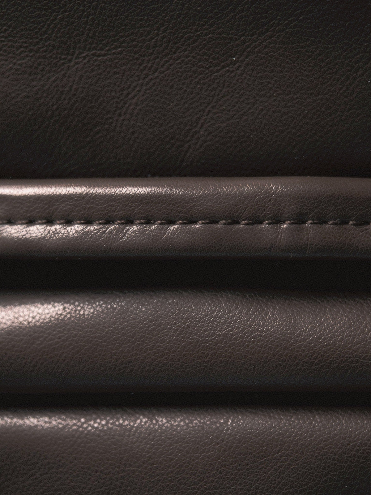 Close up of the faux leather cloth of the skirt, showing its very fine grain, its soft low sheen and the level seam low on the skirt