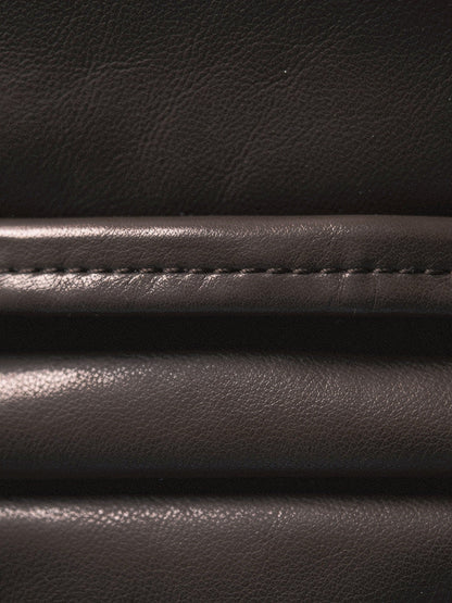 Close up of the faux leather cloth of the skirt, showing its very fine grain, its soft low sheen and the level seam low on the skirt