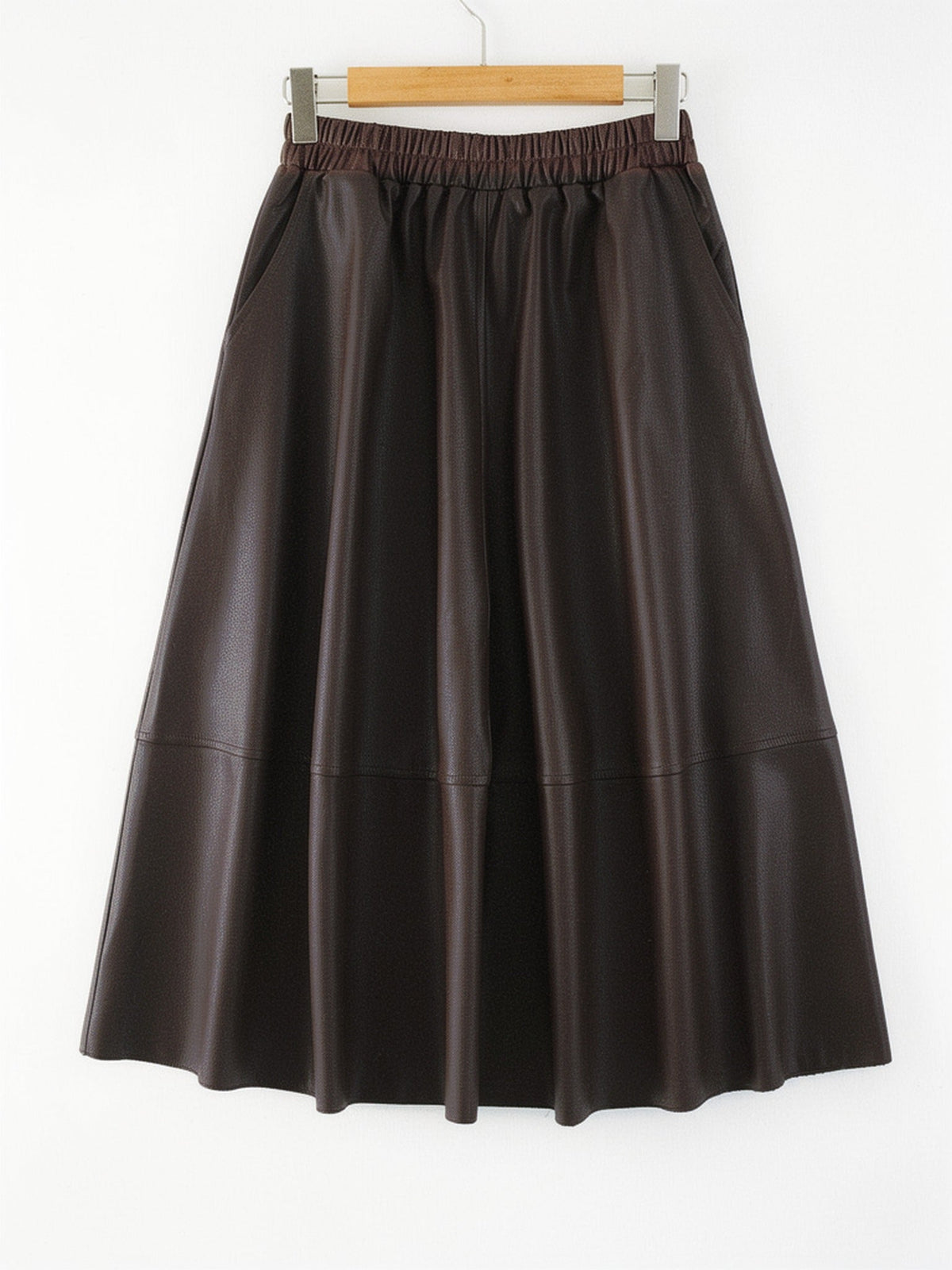 Brown faux leather skirt in Seal Brown shown front on, the gathered elastic waistband, the slanted side pockets and the full A line sweep all visible