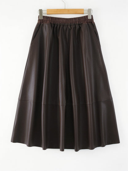 Brown faux leather skirt in Seal Brown shown front on, the gathered elastic waistband, the slanted side pockets and the full A line sweep all visible