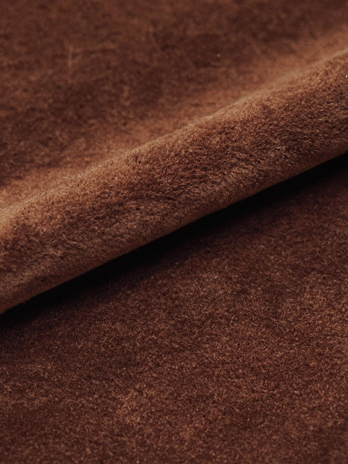 Close up of the faux suede cloth of the skirt, showing the fine matte brushed nap and a soft rolling fold