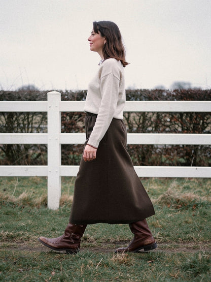 Brown skirt in a brushed A line midi cut, worn walking in profile, in Bog Oak