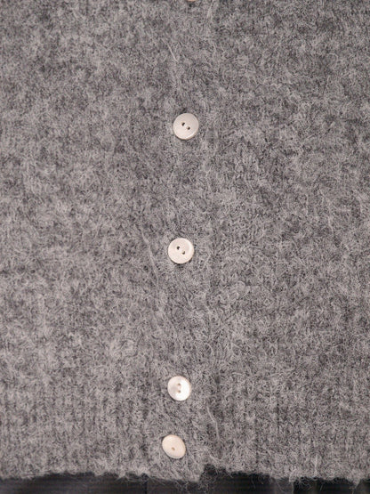 Close-up of the brushed knit fabric and pearlised button of the cardigan