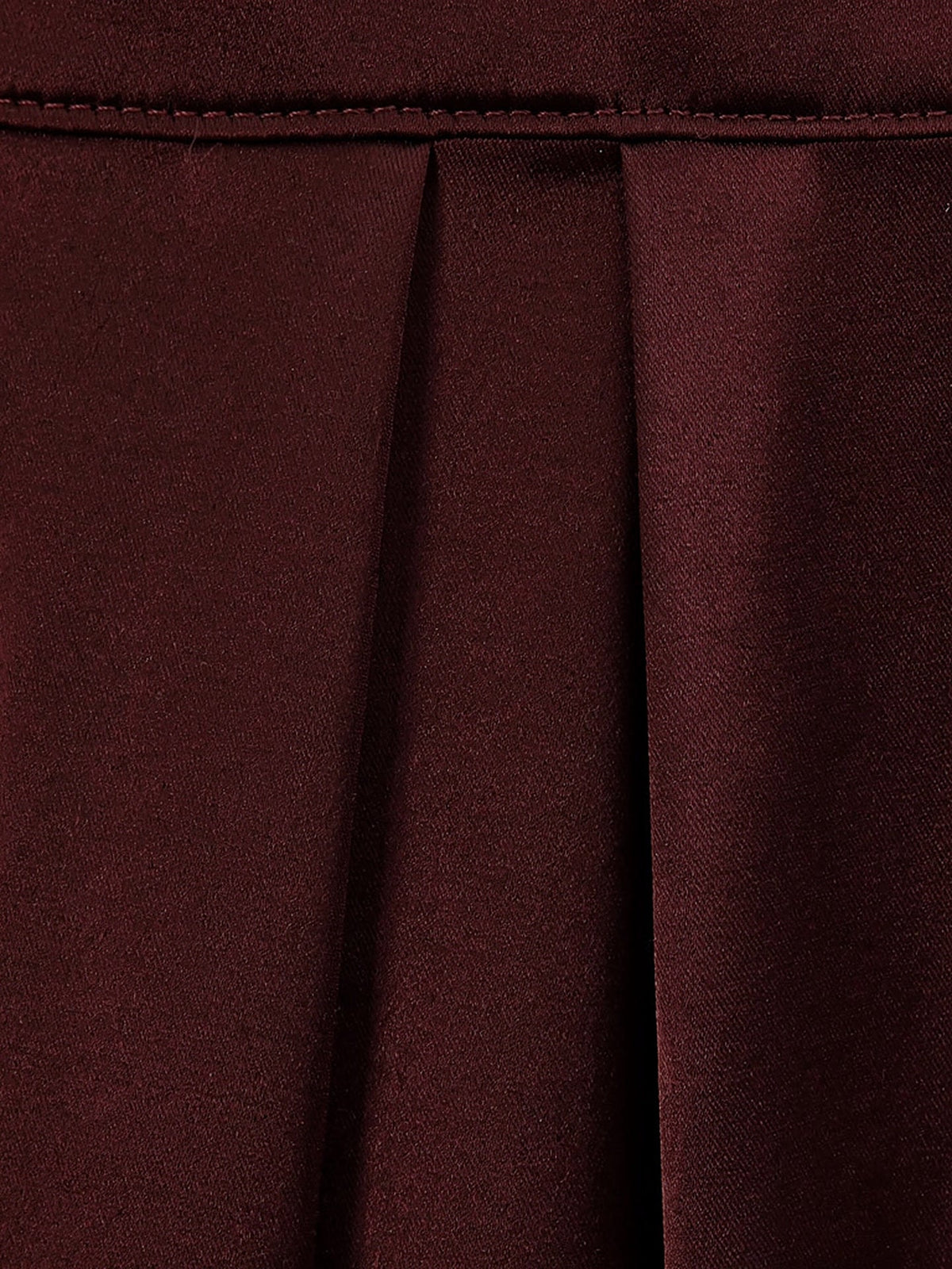 Close up of the plain satin cloth and hem of the burgundy dress in Claret