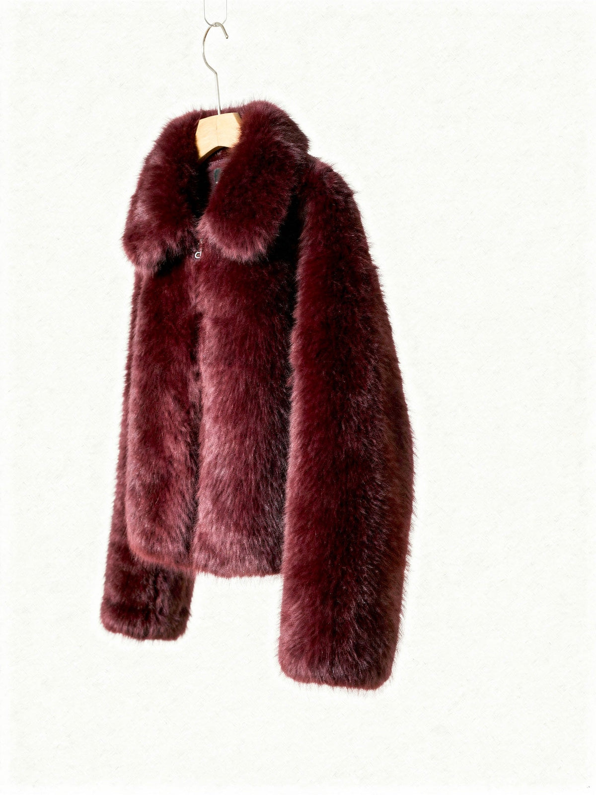 Burgundy faux fur jacket on a hanger, three quarter view showing the dropped shoulder and sleeve