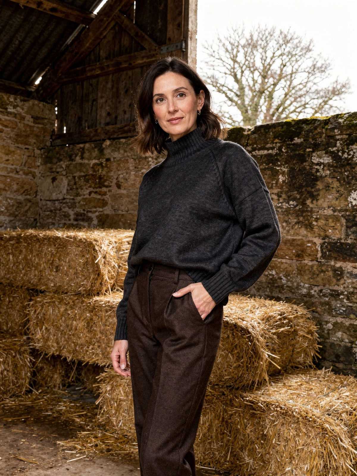 Fawsley jumper in charcoal worn with wool trousers, three-quarter view