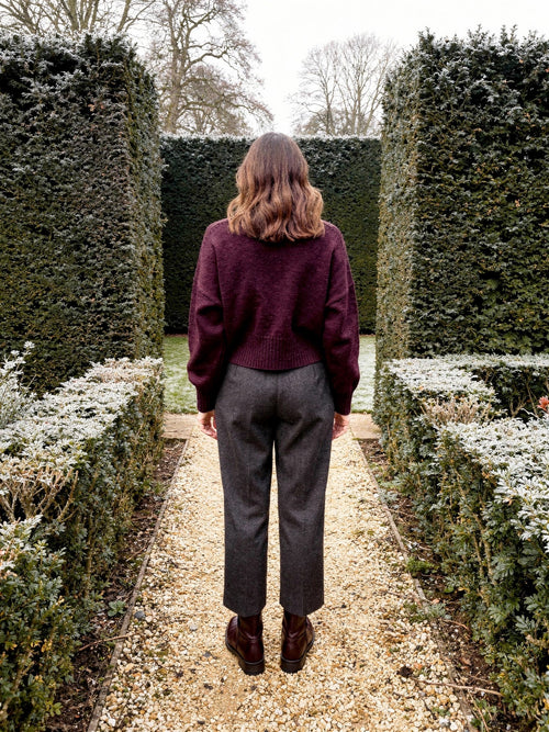 Burgundy jumper in claret marl knit, shown from the back with the ribbed hem at the natural waist