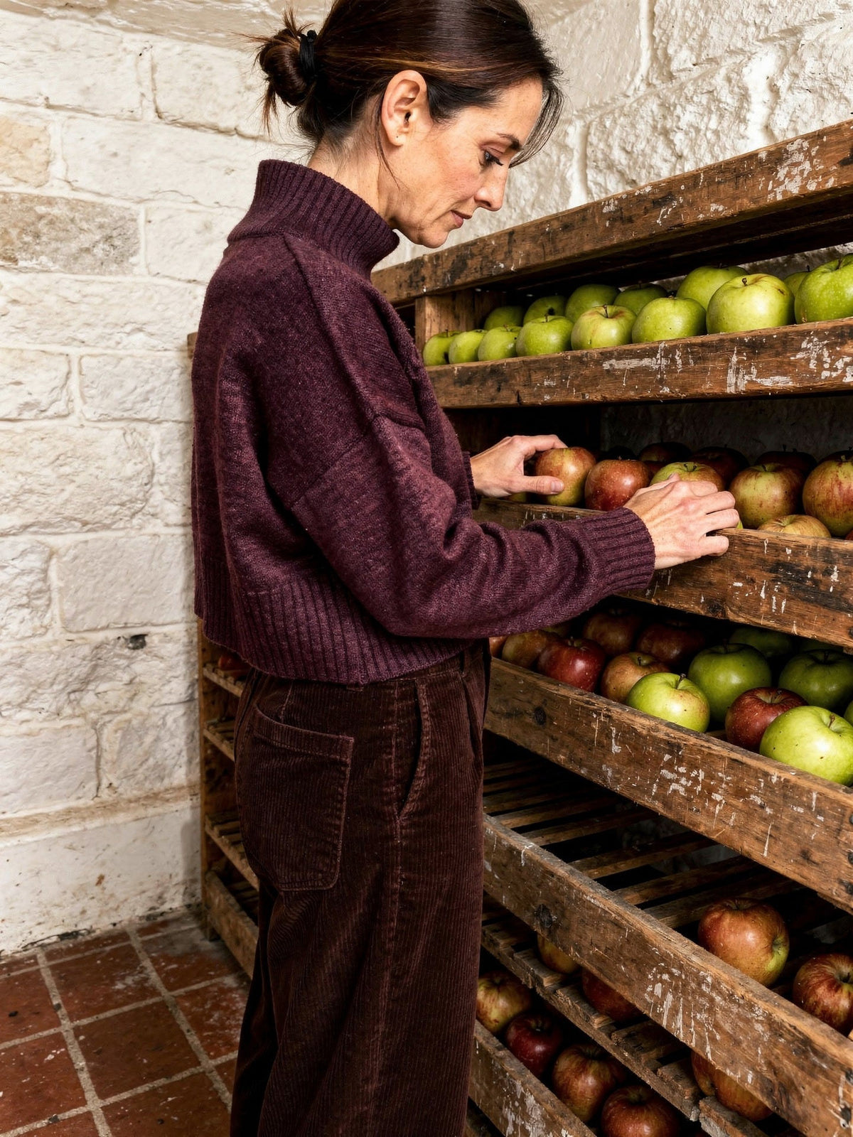 Burgundy jumper in claret worn with corduroy trousers, side view
