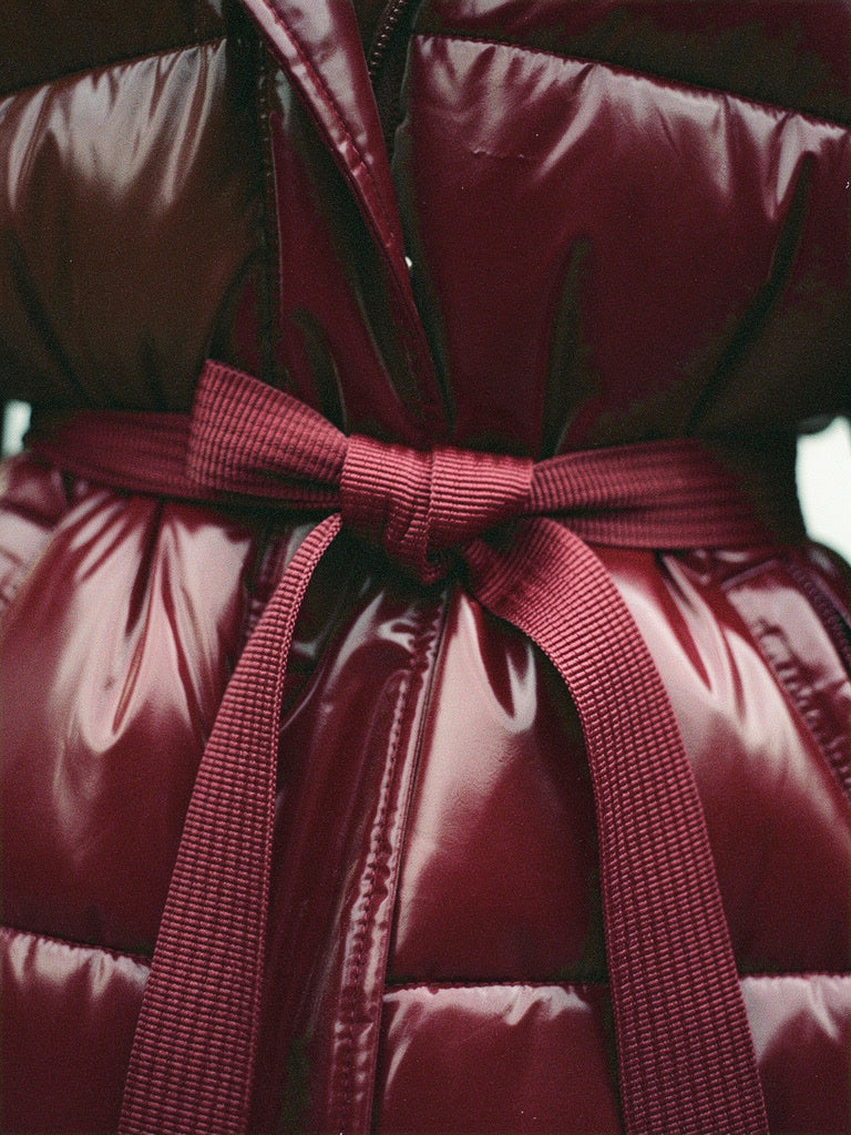 Tie belt and quilting detail of the burgundy puffer jacket