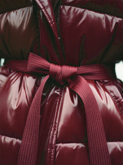 Tie belt and quilting detail of the burgundy puffer jacket