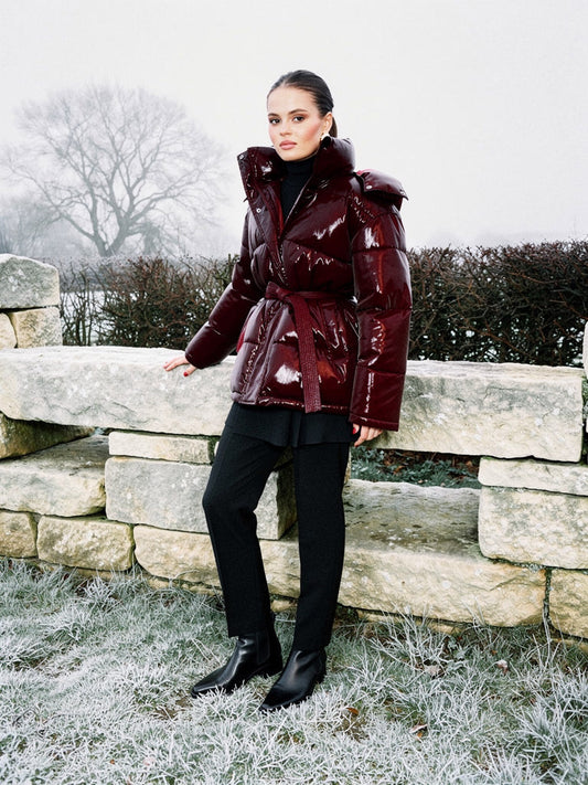 Burgundy puffer jacket in Rioja, belted and worn beside a dry stone wall