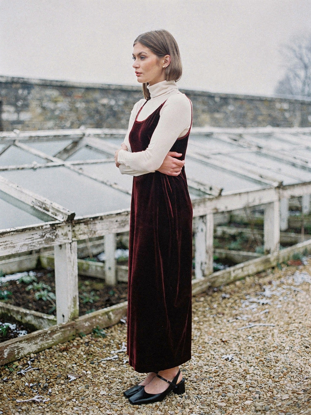 Burgundy velvet dress in Shiraz seen from the side in a frosted winter garden