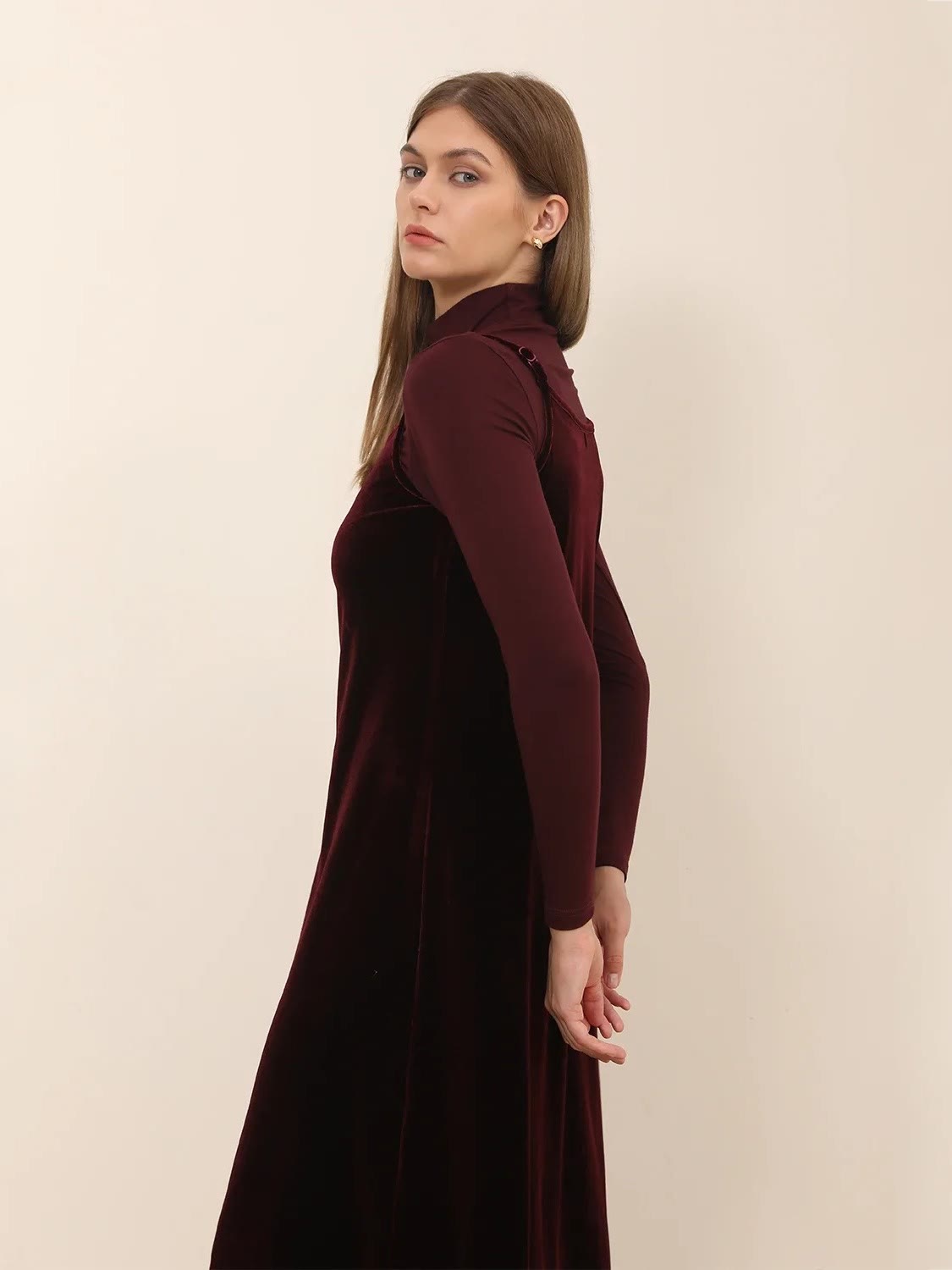 Burgundy velvet dress in Shiraz photographed from the side over a fine roll neck
