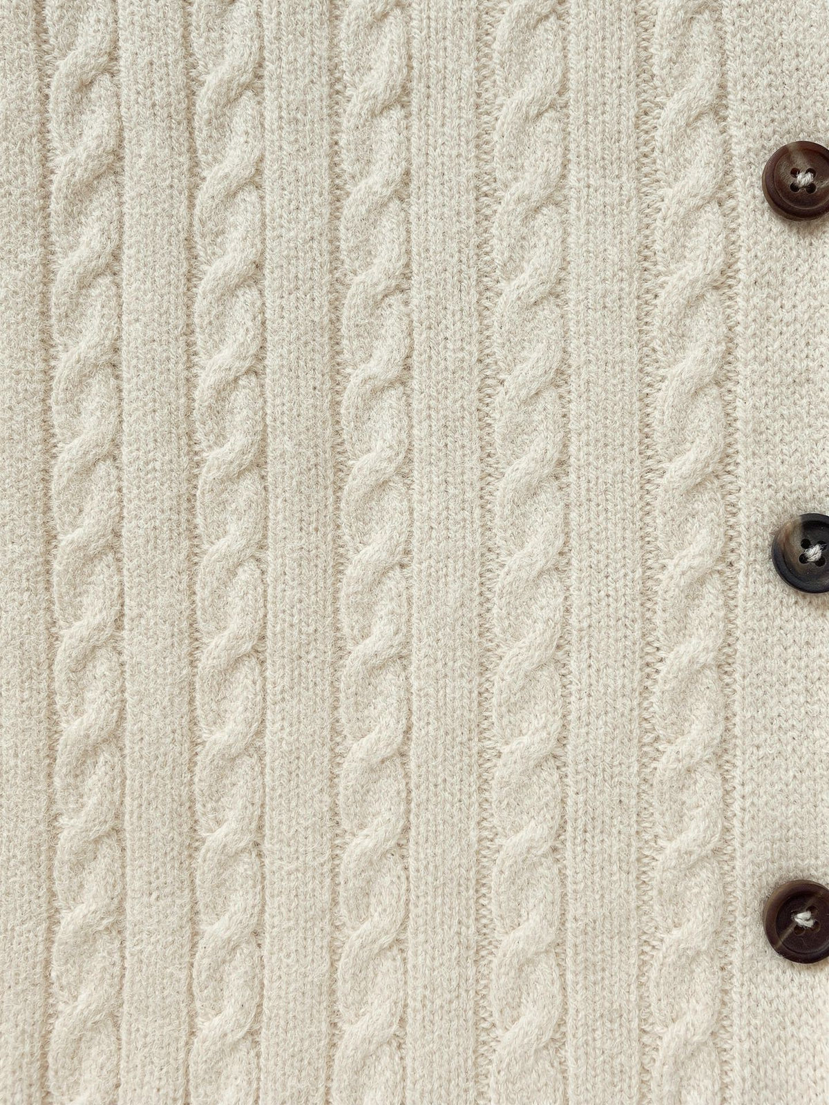 Close up of the narrow rope cables and a horn button on the Oddington cable knit cardigan