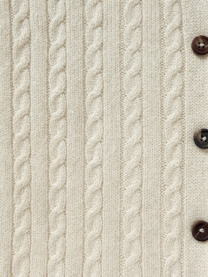 Close up of the narrow rope cables and a horn button on the Oddington cable knit cardigan