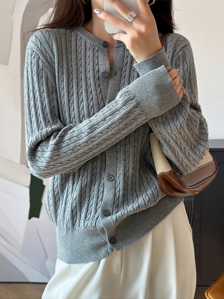 Cable knit cardigan in Harbour Grey worn buttoned with cream trousers