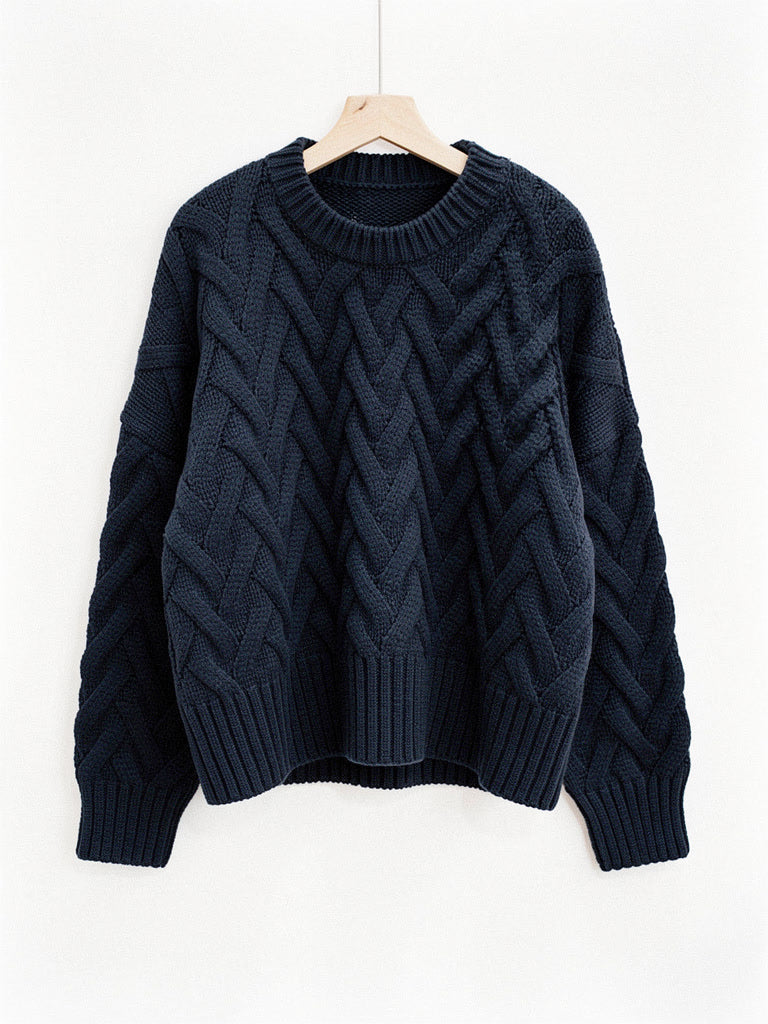 Cropped cable knit jumper in Ink Blue on a wooden hanger, front view